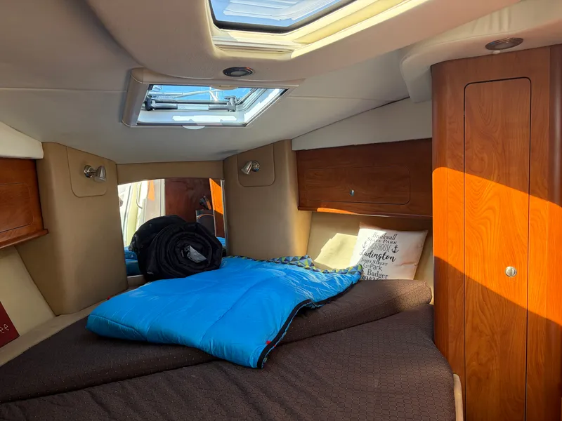 Slide: The Image of The 2013 Rinker 310 Express cabin features a cozy bed with skylights. - 17