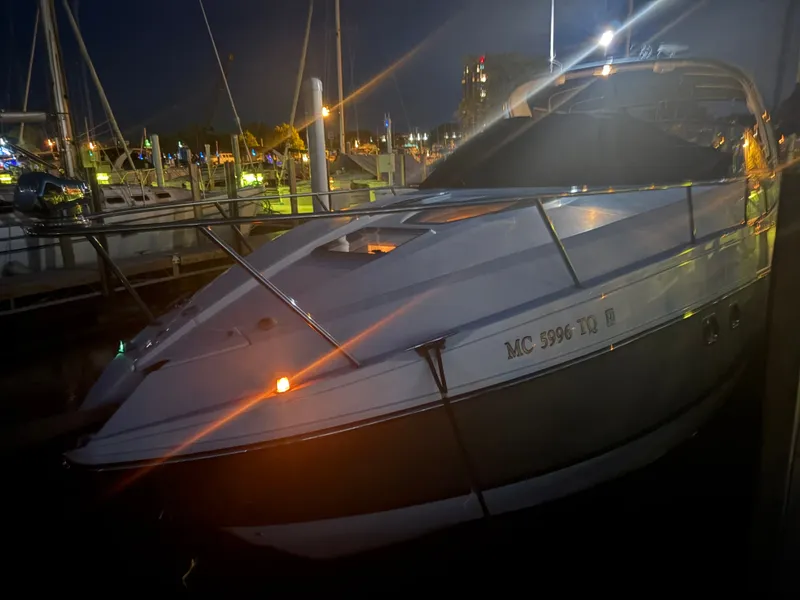 The Image of A 2013 Rinker 310 Express docked at night, surrounded by other boats. - 1