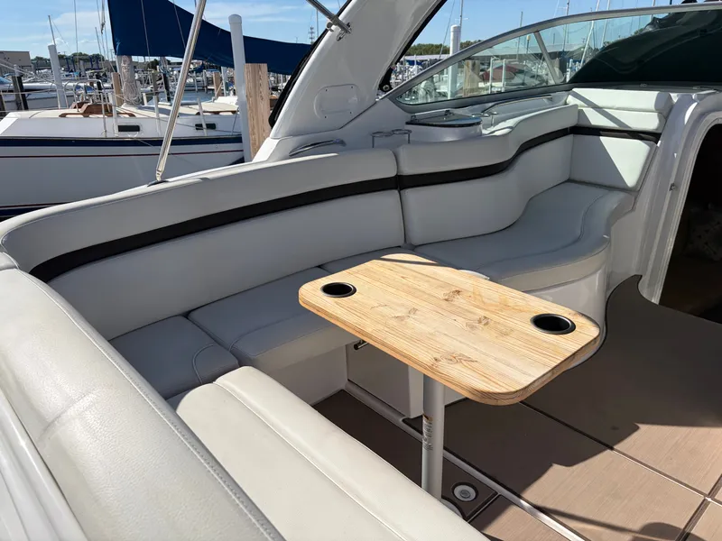 Slide: The Image of The image shows the cockpit of a 2013 Rinker 310 Express with white upholstery and a wooden table. - 21