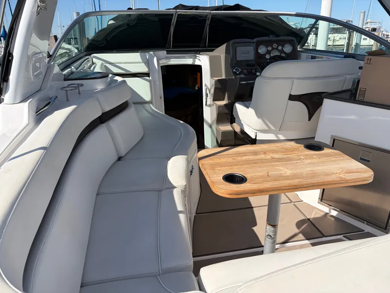 Slide: The Image of The image shows the cockpit of a 2013 Rinker 310 Express with white seating and a wooden table. - 22