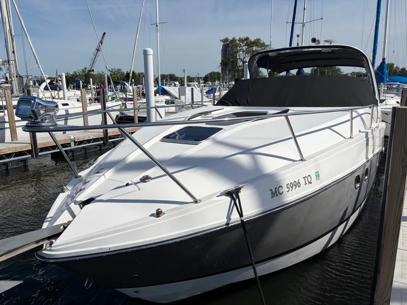 Slide: The Image of 2013 Rinker 310 Express docked with a black cover and sleek white hull. - 11
