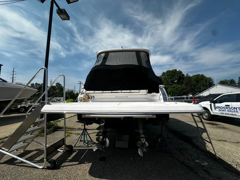 Slide: The Image of The 2021 Regal 36 Grande Coupe is parked with a black cover, surrounded by trees and vehicles. - 1