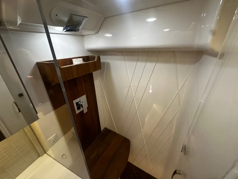 Slide: The Image of The shower in the 2021 Regal 36 Grande Coupe features modern wood paneling and white walls. - 11