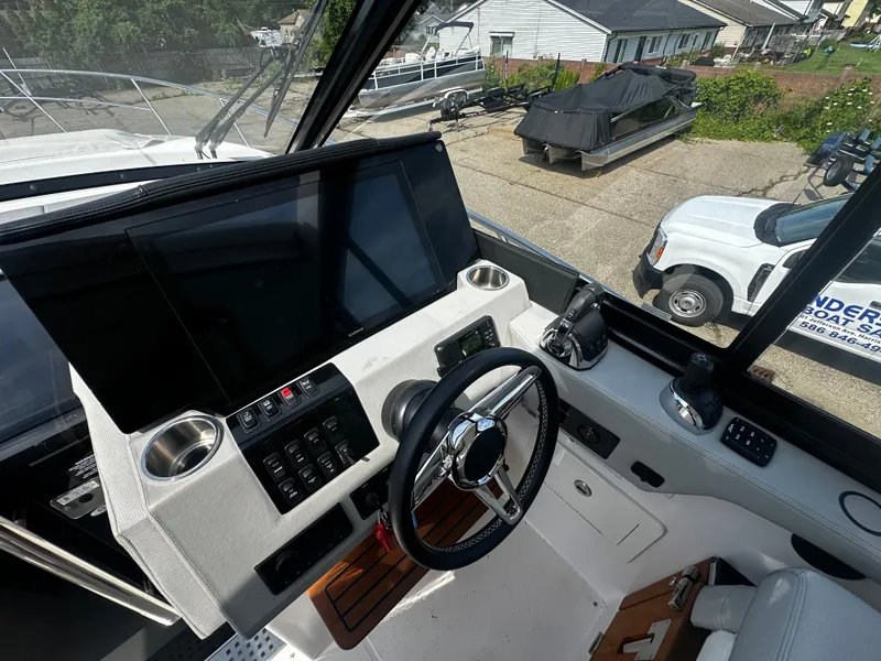Slide: The Image of The cockpit of the 2021 Regal 36 Grande Coupe with modern steering and large screens. - 13