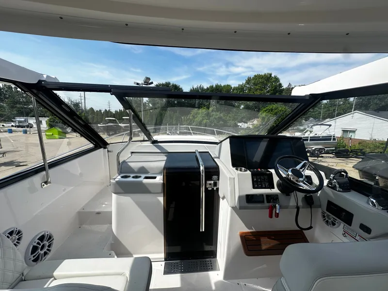 Slide: The Image of The cockpit of the 2021 Regal 36 Grande Coupe features a modern helm with large windows. - 18