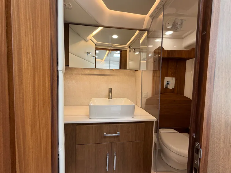Slide: The Image of The image shows a modern boat bathroom with wood paneling, a sink, and a toilet. - 15