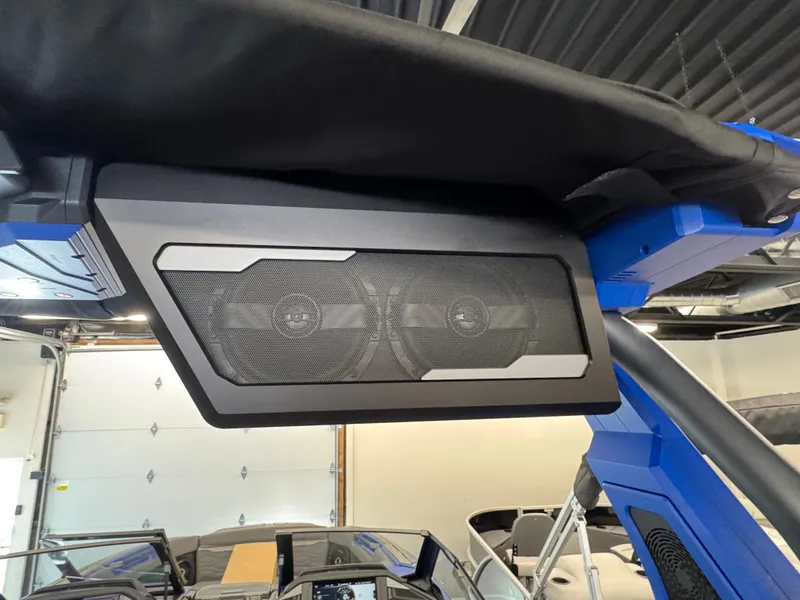 Slide: The Image of Speakers on a blue boat with a black canopy in a garage. - 15