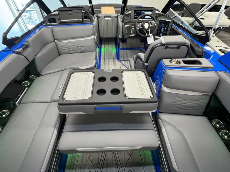 Slide: The Image of Interior of a modern boat with gray and blue seating, table, and helm console. - 17