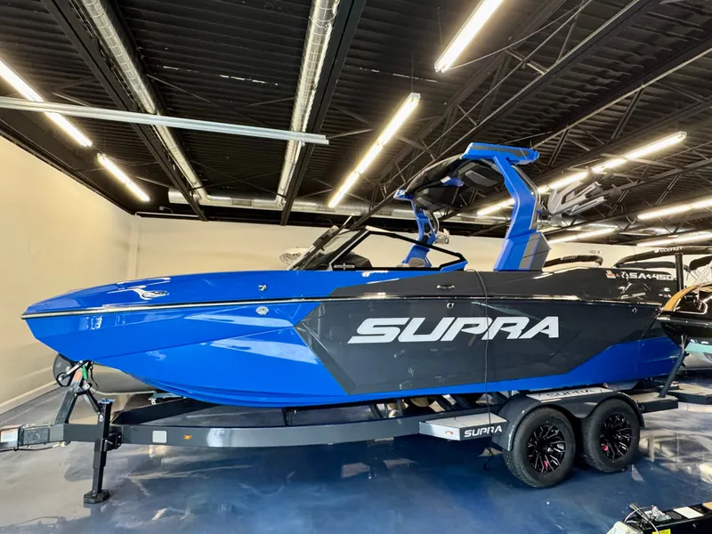 Slide: The Image of A blue 2025 Supra SA 450 sits on a trailer in a showroom. - 4