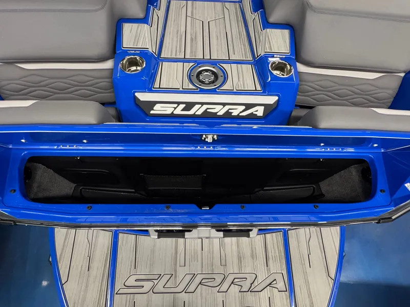 Slide: The Image of The image shows the rear of a blue Supra SA 450 boat with gray upholstery and storage space. - 11
