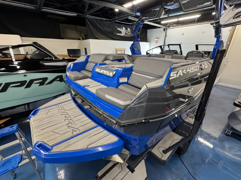 Slide: The Image of The image shows a modern 2025 Supra SA 450 boat with blue and gray accents. - 9