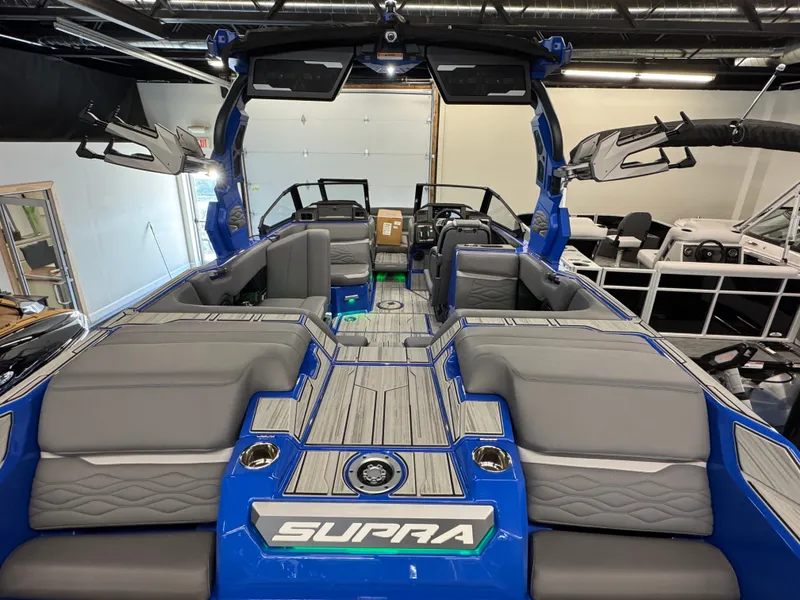 Slide: The Image of The image shows the interior of a blue Supra SA 450 boat with gray seating. - 32