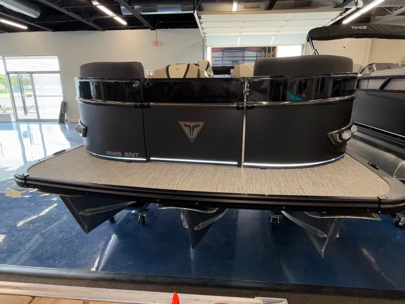 Slide: The Image of The image shows a modern pontoon boat in a showroom. It features a sleek black design. - 17