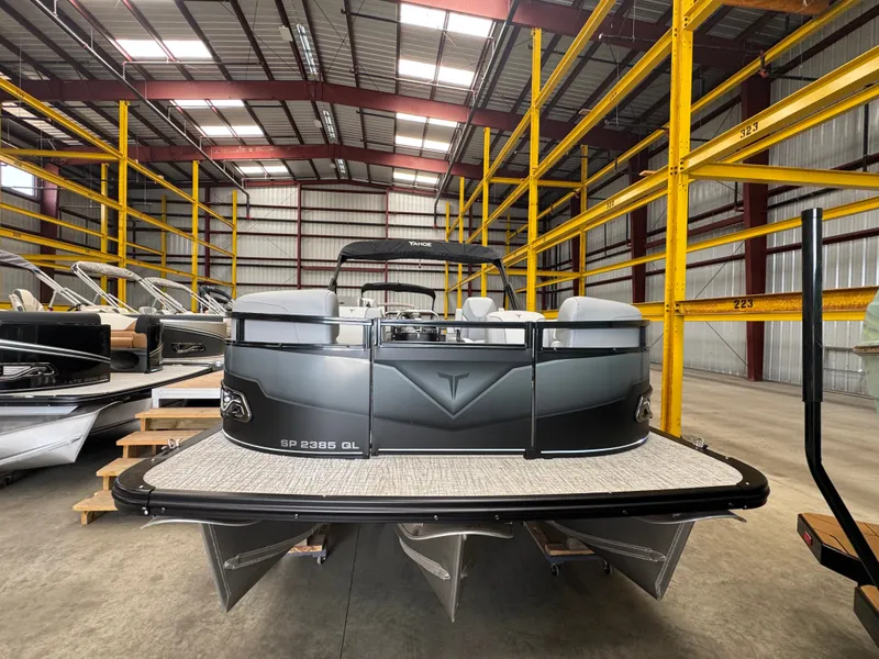 Slide: The Image of A 2025 Tahoe Sport 85 QL pontoon boat is in a warehouse with yellow shelving. - 3