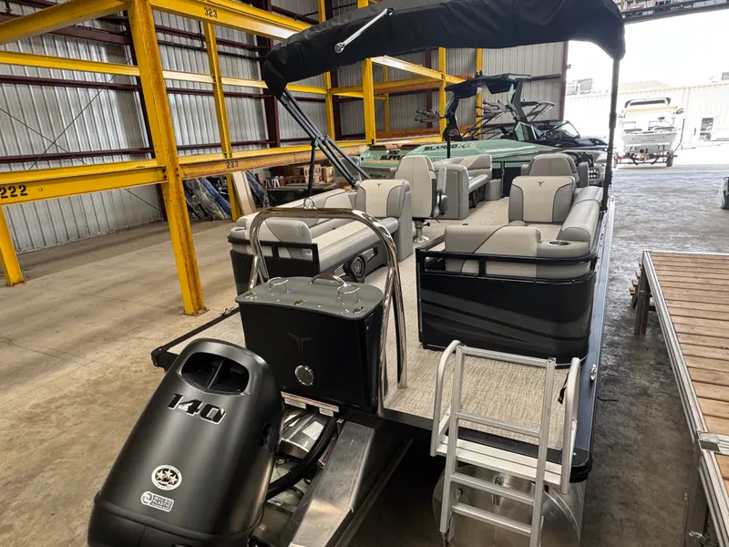 Slide: The Image of A modern pontoon boat with gray seating and a black outboard motor in a warehouse. - 4