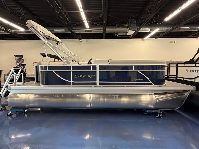 Slide: The Image of A modern pontoon boat with a blue hull and silver details, displayed in a showroom. - 1