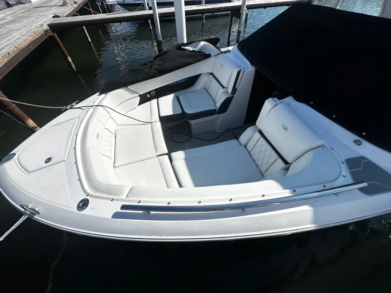 Slide: The Image of A sleek, modern boat with white upholstery and an open deck, docked at a pier. - 6