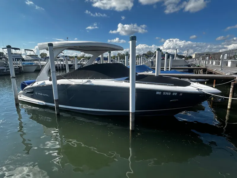 Slide: The Image of A 2023 Regal 2800 Bowrider is docked in the water. The sky is partly cloudy. - 4