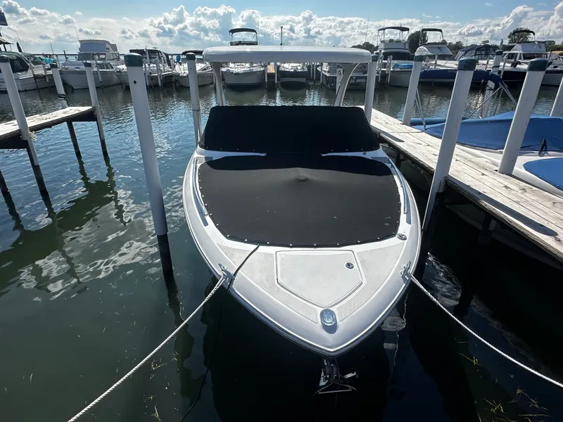 Slide: The Image of A 2023 Regal 2800 Bowrider docked, featuring a sleek black cover. - 3