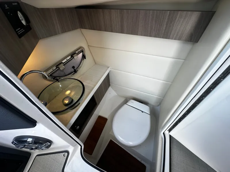 Slide: The Image of The image shows the bathroom of a 2023 Regal 2800 Bowrider with a sink and toilet. - 19