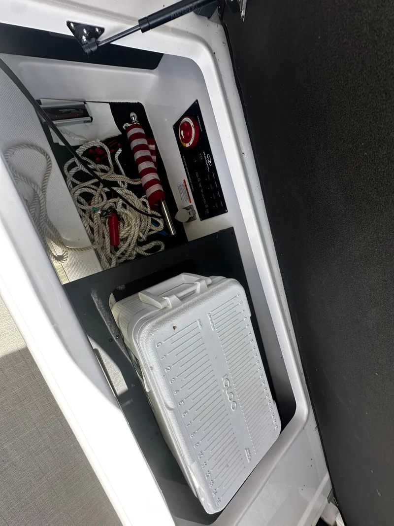 Slide: The Image of A storage compartment in the Regal 2800 Bowrider with ropes, a life ring, and a cooler. - 16
