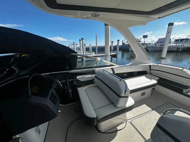Slide: The Image of The image shows the cockpit of a 2023 Regal 2800 Bowrider. It features white upholstery and a modern dashboard. - 12