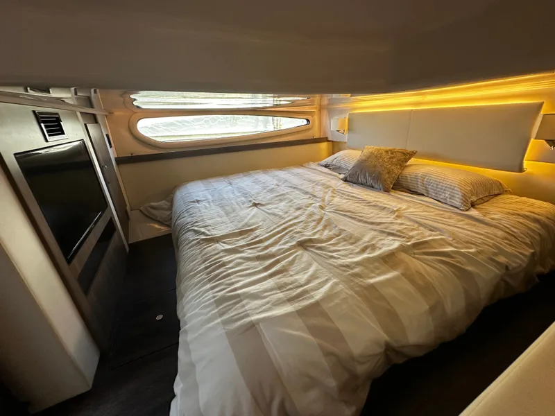 Slide: The Image of Cabin of the 2022 Regal 38 Grande Coupe with cozy bed and window. - 19