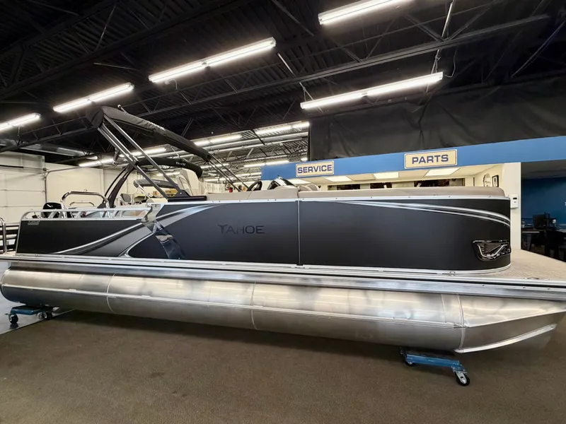 The Image of The image shows a modern pontoon boat in a showroom. It features a sleek black design. - 0