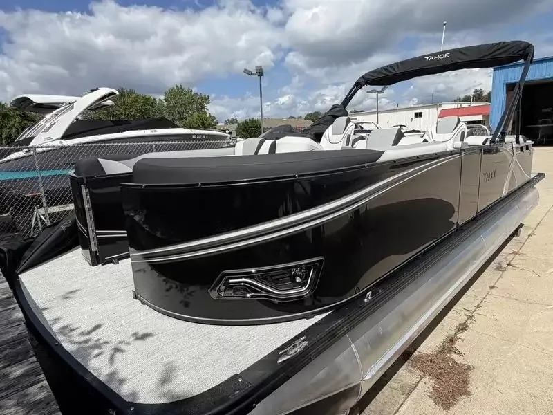 The Image of The image shows a sleek, modern pontoon boat with a black hull and white seating. - 0