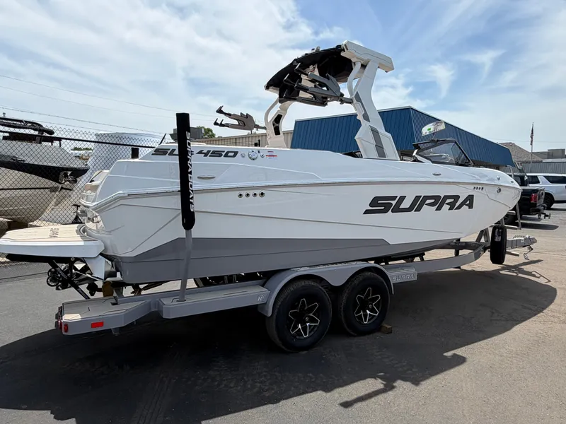 The Image of A white 2026 Supra SL 450 boat on a trailer, featuring sleek design and clean lines. - 0