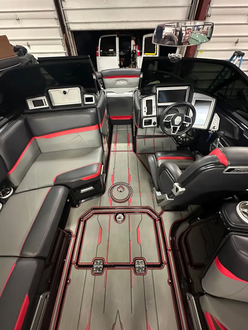 Slide: The Image of Interior of a modern boat with gray and red seating, steering wheel, and dashboard. - 15