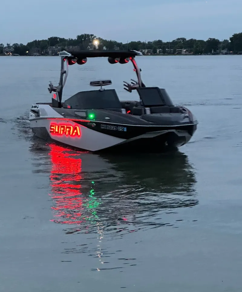 Slide: The Image of A modern motorboat with a glowing "Supra" logo cruises on a calm lake. - 20