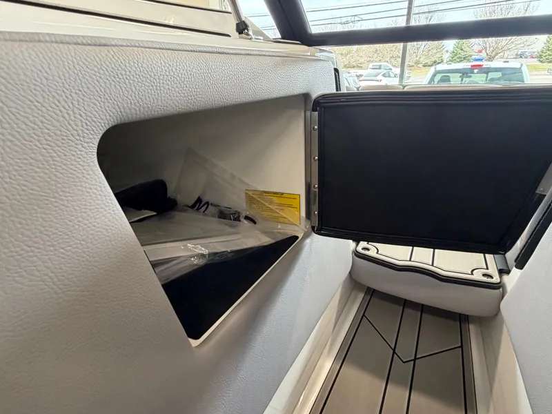 Slide: The Image of An open storage compartment on a 2026 Moomba Tykon boat with a gray interior. - 27