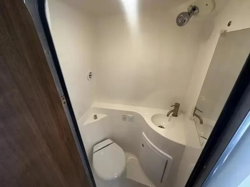 Slide: The Image of The image shows a compact boat bathroom with a toilet, sink, and shower. - 15