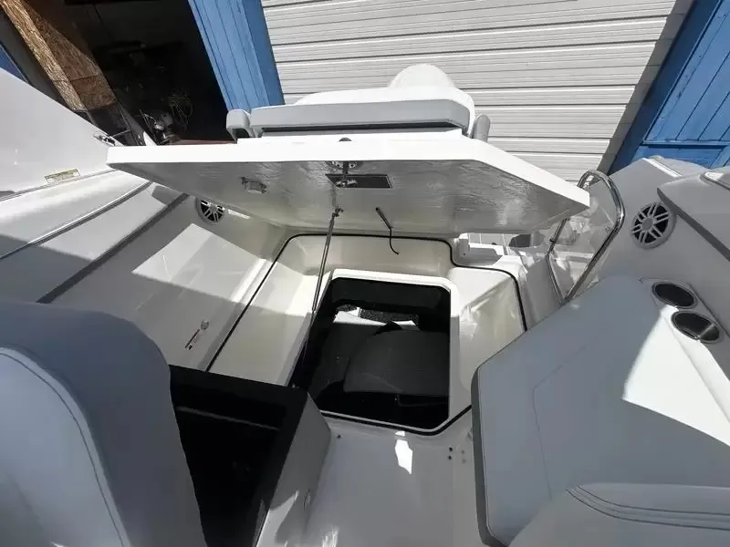 Slide: The Image of The image shows the cockpit of a 2027 Regal 26 XO boat with an open storage hatch. - 18