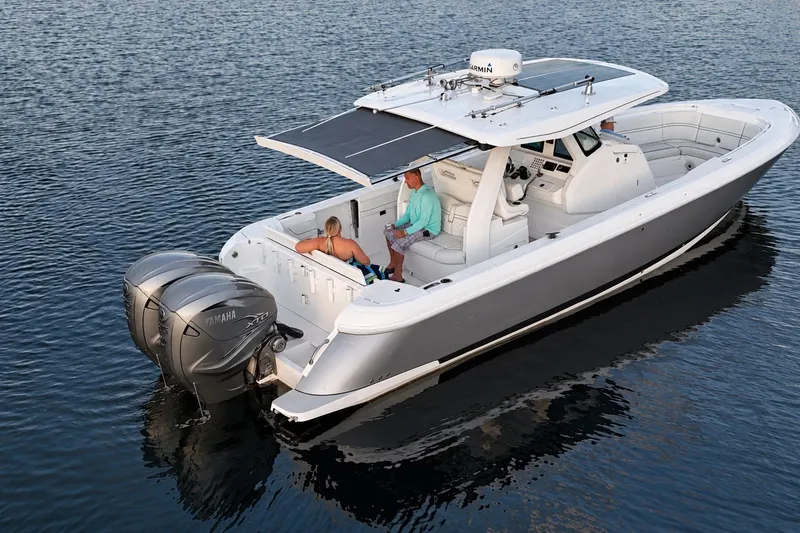 Slide: The Image of 2020 Intrepid 345 Nomad SE boat on water with Yamaha engines, featuring spacious seating. - 31