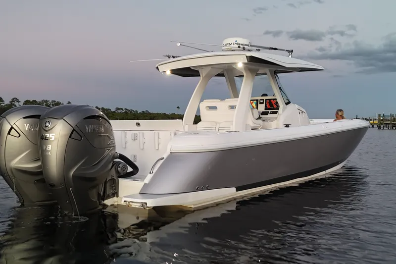 Slide: The Image of 2020 Intrepid 345 Nomad SE boat with dual Yamaha engines on calm water. - 11