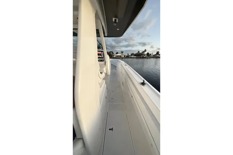 Slide: The Image of Side view of 2020 Intrepid 345 Nomad SE boat on calm water. - 38
