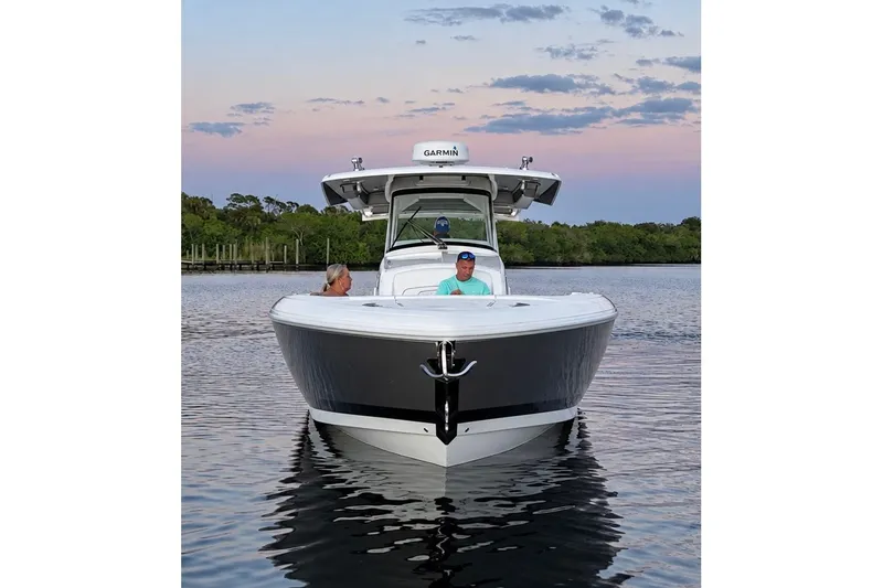 Slide: The Image of 2020 Intrepid 345 Nomad SE boat on calm water at sunset. - 6