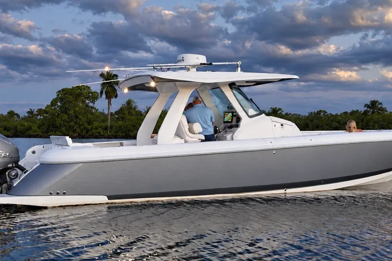 Slide: The Image of 2020 Intrepid 345 Nomad SE boat cruising on calm water at sunset. - 28