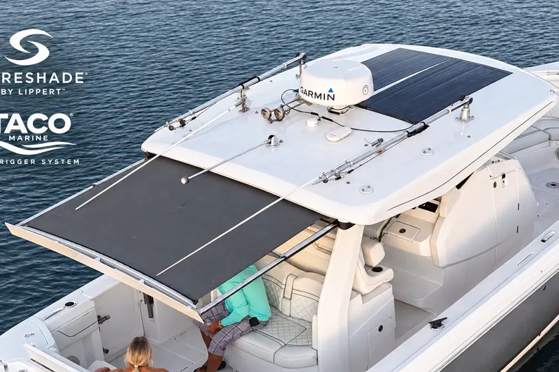 Slide: The Image of 2020 Intrepid 345 Nomad SE boat with Garmin equipment and retractable sunshade on water. - 18