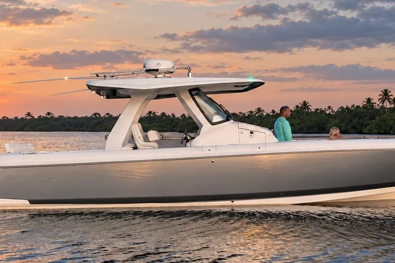 Slide: The Image of 2020 Intrepid 345 Nomad SE boat cruising at sunset on calm waters. - 1