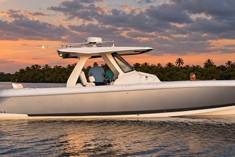Slide: The Image of 2020 Intrepid 345 Nomad SE boat cruising at sunset with scenic background. - 2