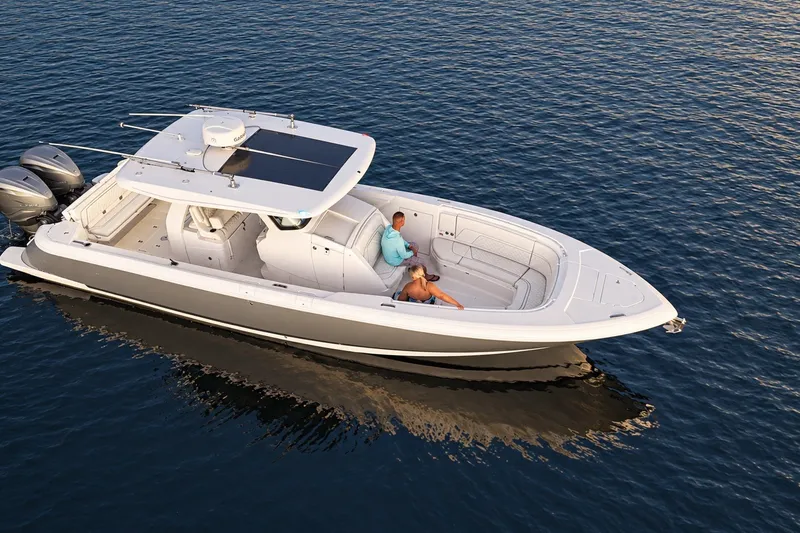 Slide: The Image of 2020 Intrepid 345 Nomad SE boat cruising on calm blue waters. - 13