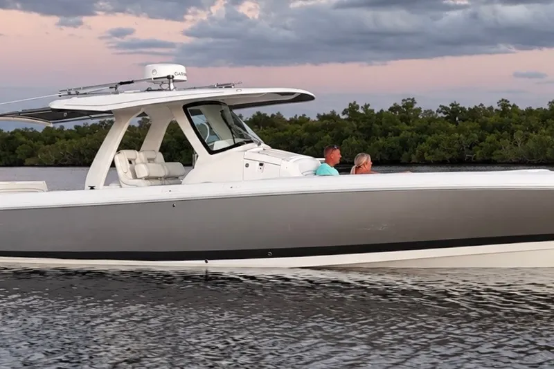 Slide: The Image of 2020 Intrepid 345 Nomad SE boat cruising on calm water at sunset. - 14