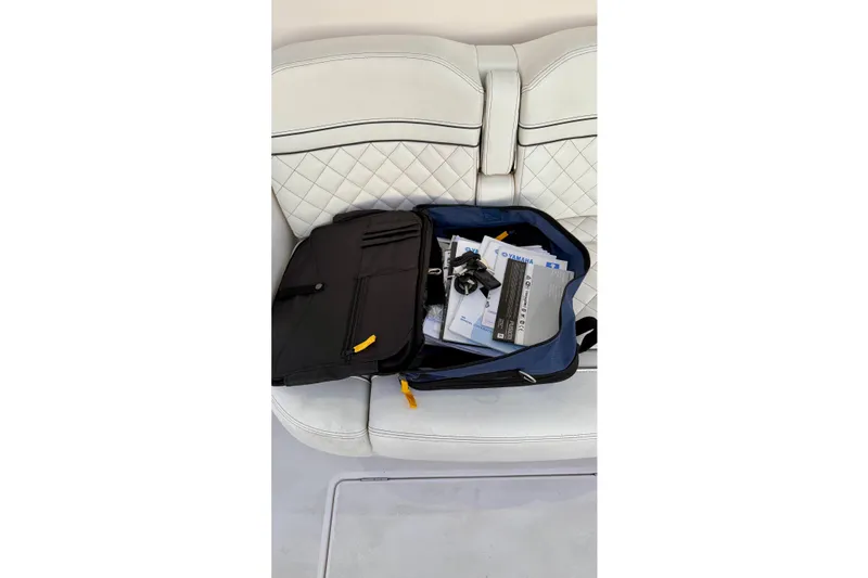 Slide: The Image of Open bag with documents and cables on white quilted seat, Intrepid 345 Nomad SE, 2020. - 44