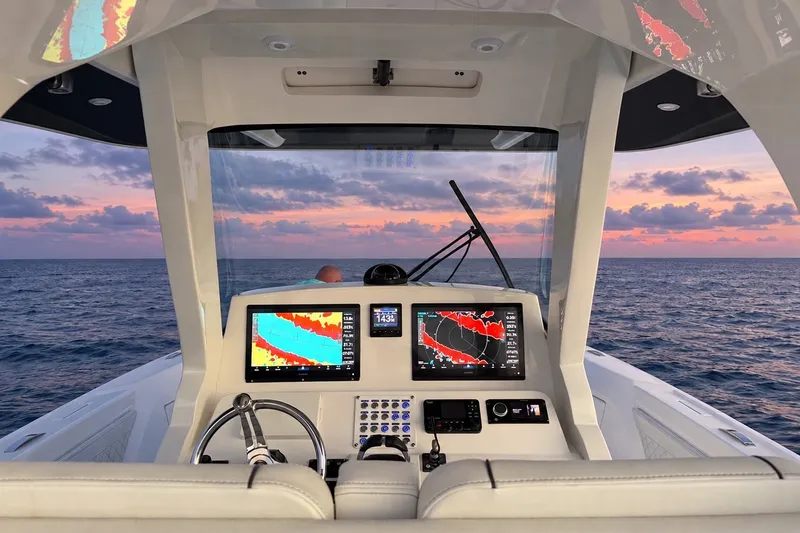 Slide: The Image of Intrepid 345 Nomad SE 2020 boat dashboard with navigation screens at sunset on the ocean. - 17