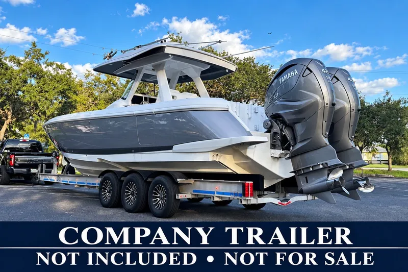 Slide: The Image of 2020 Intrepid 345 Nomad SE boat on trailer, twin Yamaha engines, clear sky background. - 51