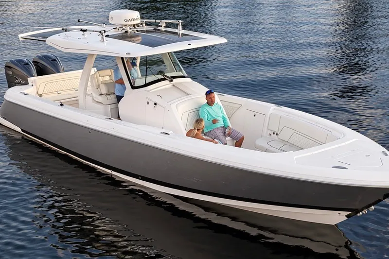 Slide: The Image of 2020 Intrepid 345 Nomad SE boat cruising on calm water with passengers onboard. - 29