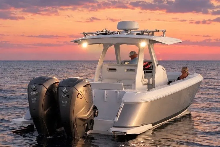 Slide: The Image of 2020 Intrepid 345 Nomad SE boat on water at sunset with dual engines. - 5